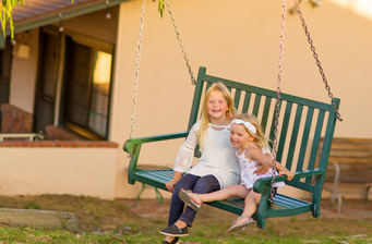 Two children having fun on our outdoor swinging chair.
